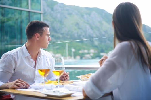 happy young couple having lanch at beautiful restaurant on by the sea on  beach