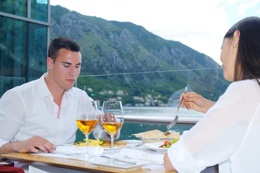 happy young couple having lanch at beautiful restaurant on by the sea on  beach