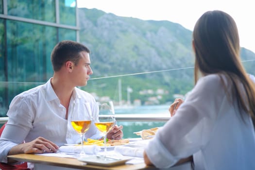 happy young couple having lanch at beautiful restaurant on the beach