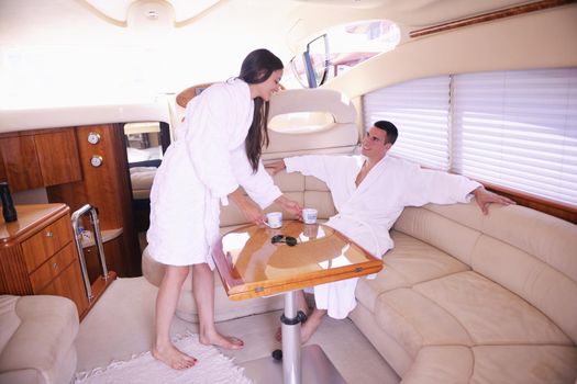 Romantic young couple spending time together and relaxing on yacht