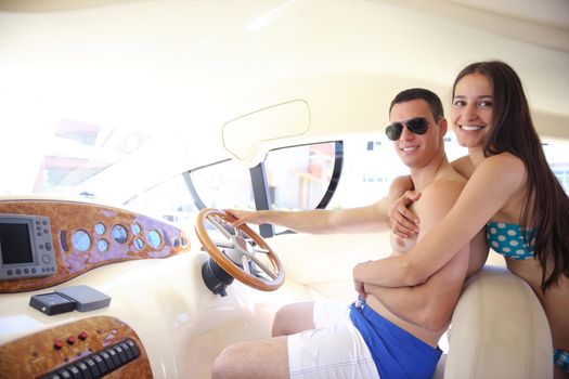 Romantic young couple spending time together and relaxing on yacht