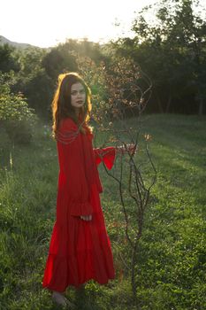 attractive woman in red dress outdoors fresh air summer. High quality photo