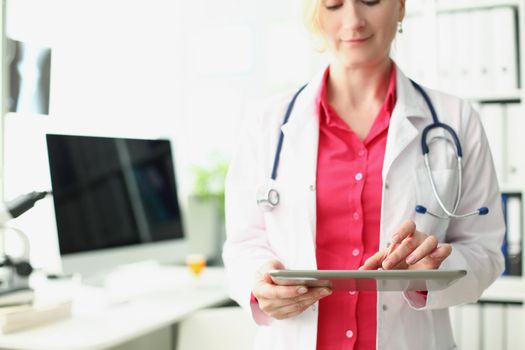 Portrait of professional medical worker use modern tablet device for work in clinic. Doctor in uniform hold new gadget. Development, healthcare concept