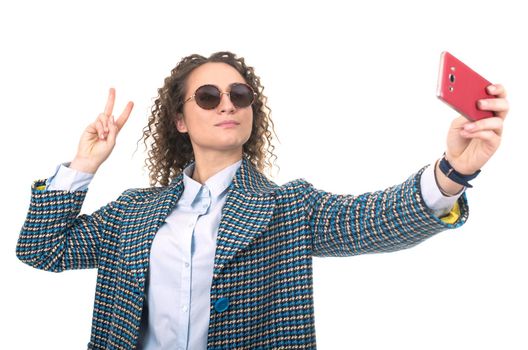 Close up portrait of a cute lovely woman taking selfie and showing peace sign with fingers over white background