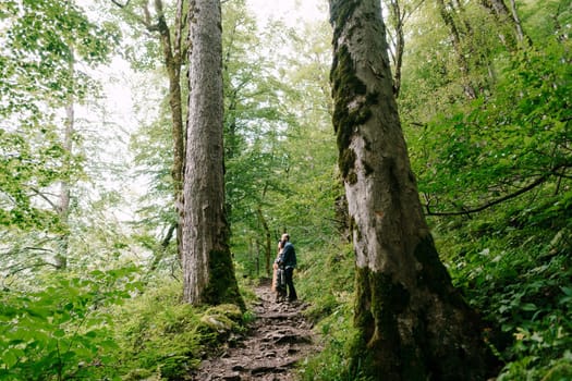 Woman and man stand on the path on the slope in the park. High quality photo