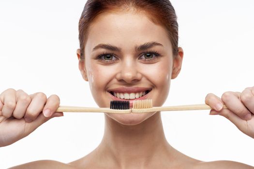 cheerful woman with bare shoulders toothbrushes hygiene oral care. High quality photo