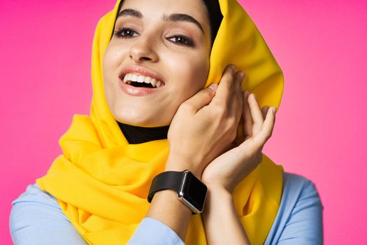 muslim woman with smart watch technology posing pink background. High quality photo