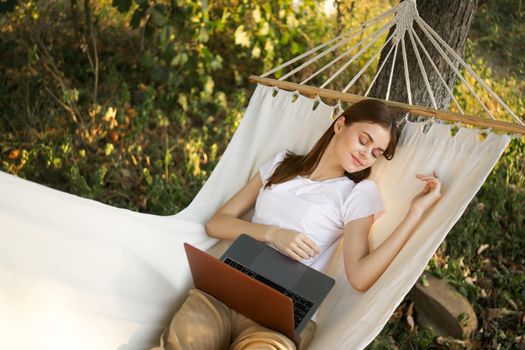 woman lies on a hammock with laptop travel vacation internet. High quality photo