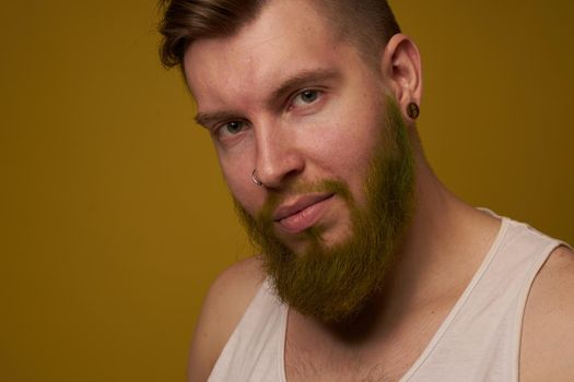 a bearded man with a serious expression in a white t-shirt with tattoos on his arms. High quality photo