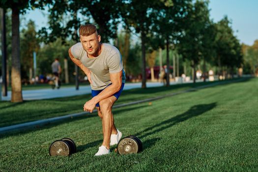 male athlete park with dumbbells doing CrossFit exercise. High quality photo