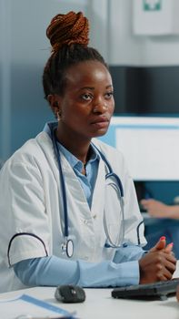 Medical specialist doing healthcare consultation with sick patient in doctors office. Woman working as doctor consulting person with illness for checkup visit and healing treatment.