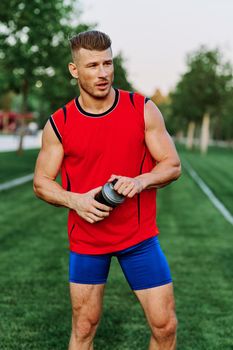 Cheerful sporty man in the park on green grass doing exercises. High quality photo