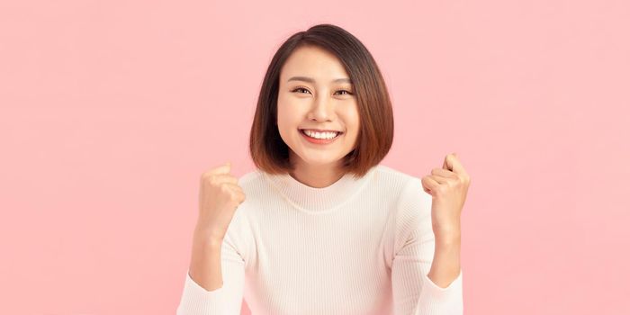 Beautiful young woman over isolated background excited for success with arms raised celebrating victory smiling. Winner concept.