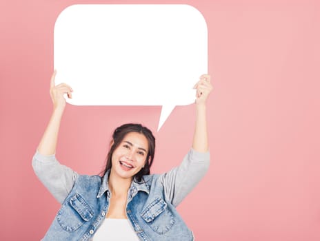 Happy Asian beautiful young woman smiling excited wear denims holding empty speech bubble sign, Portrait female posing show up for your idea looking at camera, studio shot isolated on pink background