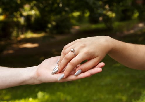 man and woman holding hands. hands closeup. outdoor on summer day