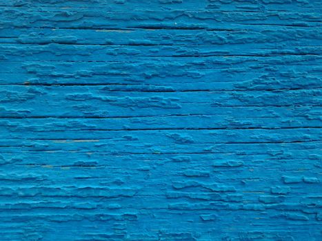Texture of old paint on the wooden surface. Background of cracked blue paint, close-up