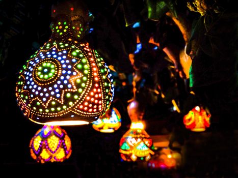 Oriental lanterns glow with multicolored lights in the dark. Eastern fairy tale.