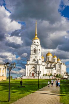 Vladimir, Russia - August 04, 2016: Assumption Cathedral. White orthodox temple with golden domes in the setting sun on the background beautiful sky.