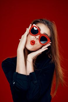 pretty woman wearing sunglasses fashion posing hairstyle red background. High quality photo