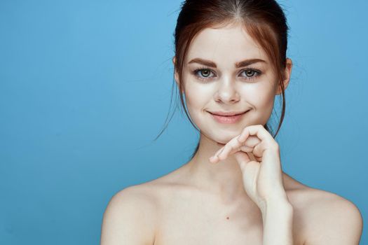 woman with bared shoulders pigtail emotions posing blue background. High quality photo