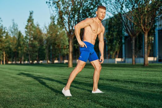 man with muscular body exercising in summer park. High quality photo