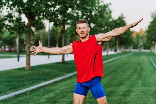 athletic man in red tank top posing outdoors fitness. High quality photo