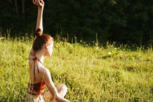 woman in the field sitting on the grass meditation rest. High quality photo