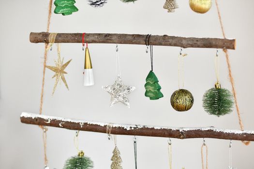 Handmade wooden Christmas tree with toys hanging on the wall