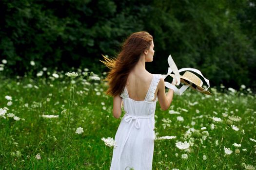 Woman in white dress hat nature field flowers. High quality photo