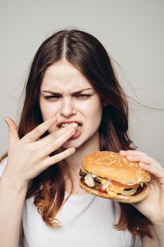 woman with a hamburger in her hands a snack fast food close-up. High quality photo