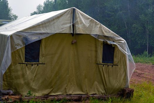 Military tent in the field. field camp in nature. large green tarpaulin tent. temporary field camp.