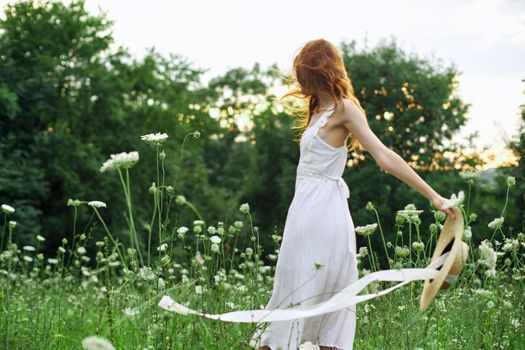 pretty woman in a field in nature white dress fresh air. High quality photo