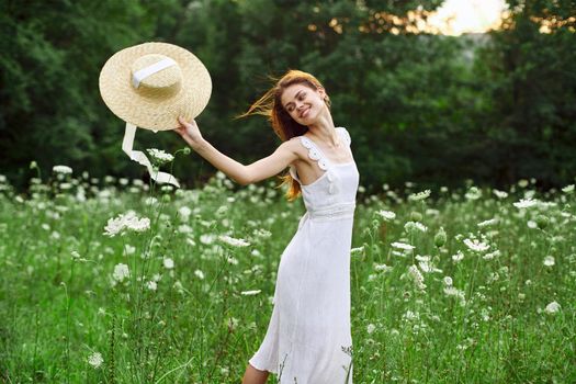 Woman in white dress hat holding flowers nature walk. High quality photo