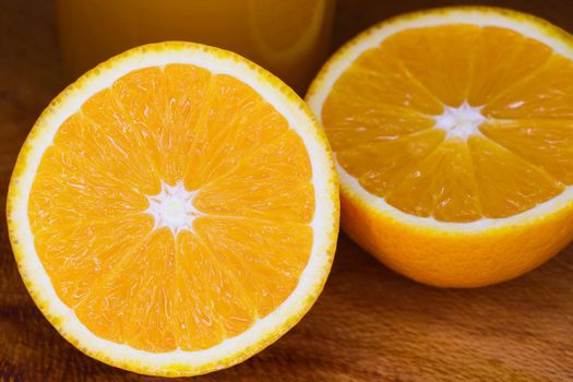 Freshly cut Valencia orange citrus fruit (Citrus x sinensis) close-up on wood