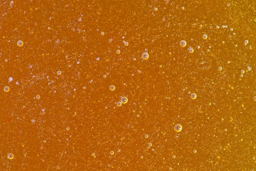 Natural unfiltered raw golden amber honey full frame close-up