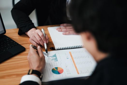Diverse businesspeople discuss financial report in charts diagrams and graphs close up, business partners analysing common sales statistics presenting deal benefits at group meeting concept.