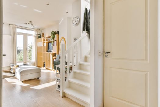 Luxurious corridor leading to the living room with a white wooden staircase