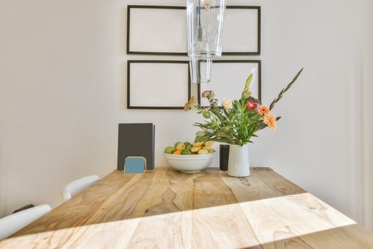 Luxurious wooden table with a bowl of fruit and a vase of flowers