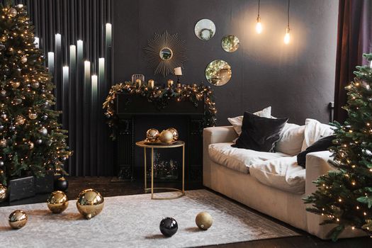 Christmas interior with a beautiful Christmas tree, sofa, light bulbs and dark background. Home New Year's interior.