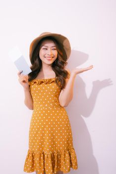 Travel concept portrait of smiling woman holding passport with ticket showing copy paste