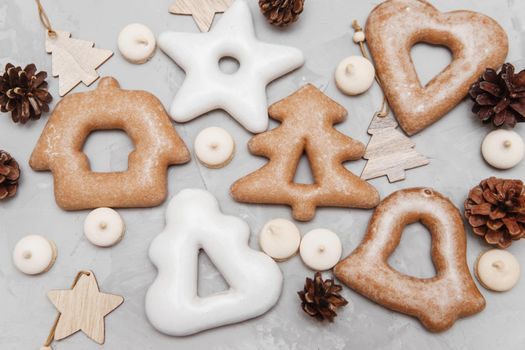 Banner for Christmas and New Year gingerbread stars, houses, Christmas trees, toys on a gray concrete background, Christmas lights bokeh in the foreground.