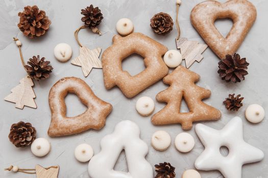 Banner for Christmas and New Year gingerbread stars, houses, Christmas trees, toys on a gray concrete background, Christmas lights bokeh in the foreground.