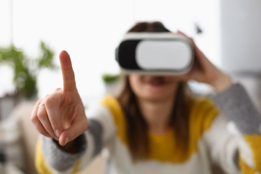 Close-up of womans finger trying to touch invisible things wearing virtual reality glasses. Female explore new world in device. Technology, pastime concept