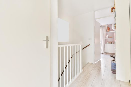 Closed white room door next to the top of the stairs of the house