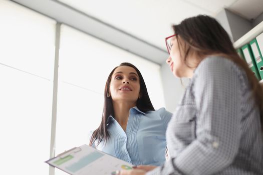 Portrait of female coworkers discussing report business growth and statistics. Colleagues in company office create strategy. Business, job, career concept