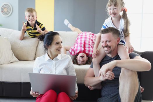 Portrait of happy smiling family spend time together in living room. Father mother and children laugh and go crazy. Family, childhood, parenthood concept