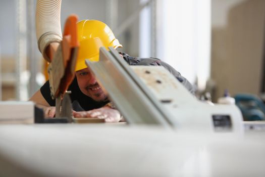 Close-up of qualified male worker using electric saw equipment for work with wood. Handyman on workplace, diy inspiration. Fix, renovation, repair concept