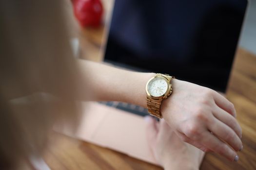 Close-up of office worker woman look at time on wristwatch and wait end of shift. Female late and check time, in rush home. Job, accessory, timing concept