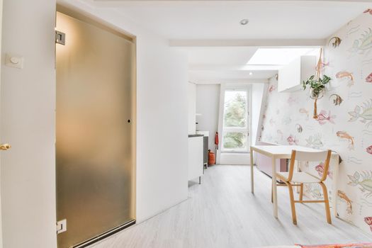 Corner light room with a miniature window and a white table and chair