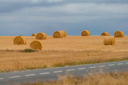 Road and straw balls under the stormy sky, long shot